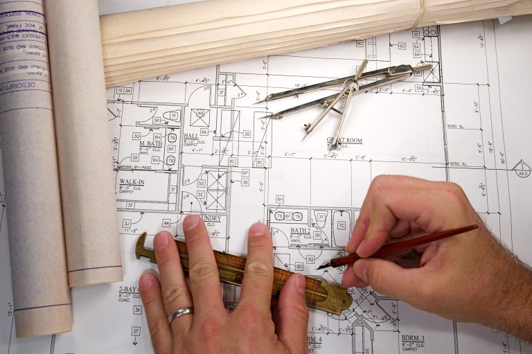 Zwei Hände mit Bauplan eines Bauzeichners
